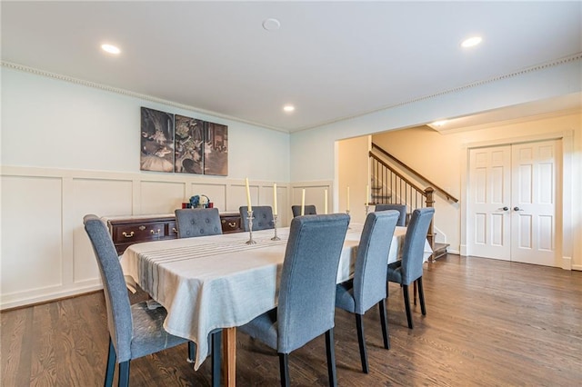 dining area featuring dark wood-type flooring and crown molding