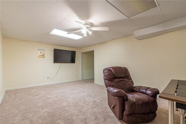 living area with a paneled ceiling, ceiling fan, and carpet flooring