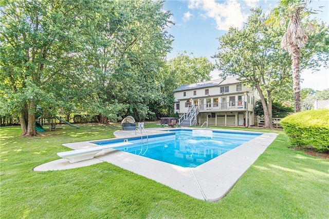 view of pool featuring a diving board, a lawn, and a wooden deck