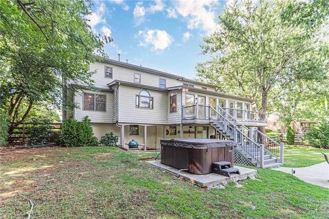 back of property featuring a patio area, a hot tub, a yard, a deck, and a sunroom