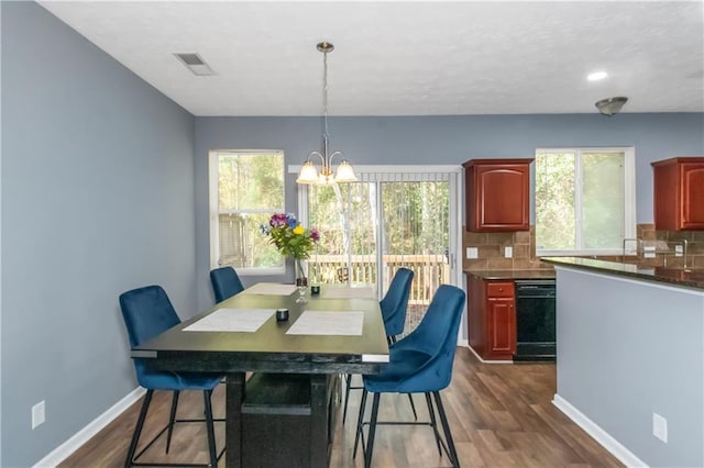 dining room featuring a wealth of natural light, dark hardwood / wood-style flooring, and a chandelier