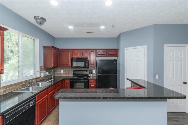 kitchen with black appliances, plenty of natural light, and a kitchen island