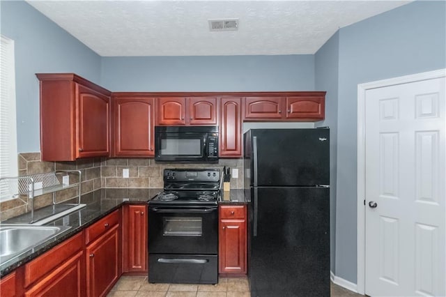 kitchen featuring light tile patterned flooring, tasteful backsplash, dark stone counters, and black appliances