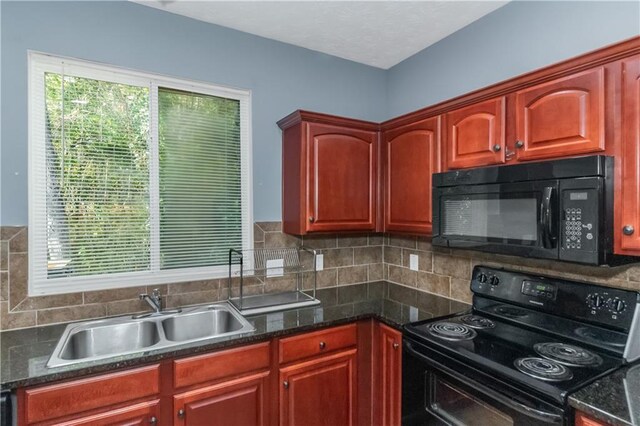 kitchen featuring backsplash, sink, dark stone counters, and black appliances