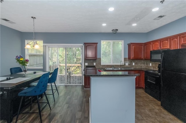 kitchen featuring a center island, dark wood-type flooring, black appliances, sink, and tasteful backsplash