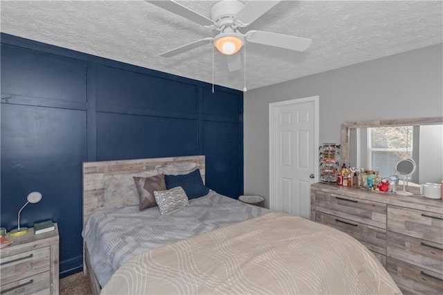 bedroom with ceiling fan and a textured ceiling