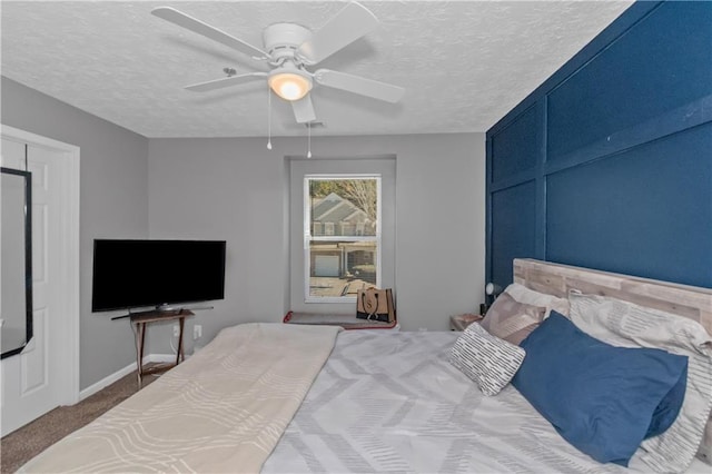 bedroom featuring carpet flooring, a textured ceiling, and ceiling fan