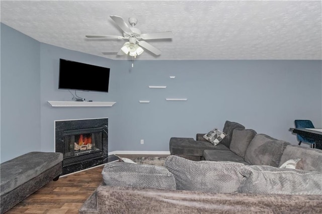 living room featuring ceiling fan, wood-type flooring, and a textured ceiling