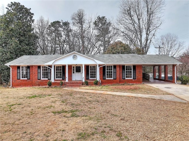 ranch-style house with brick siding, covered porch, an attached carport, driveway, and a front lawn