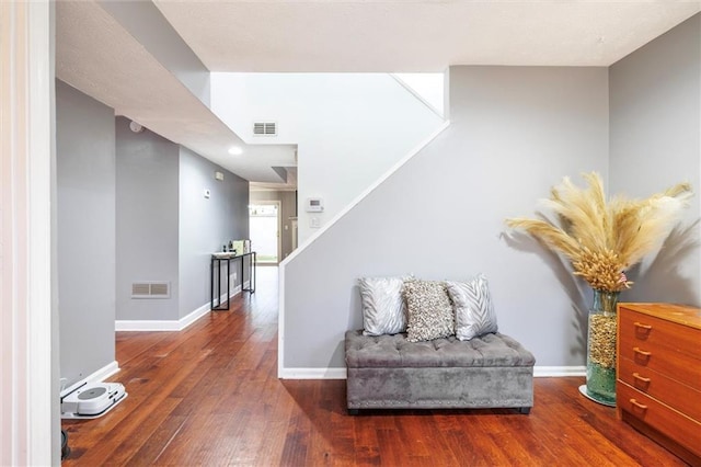 interior space featuring baseboards, visible vents, hardwood / wood-style floors, and stairs