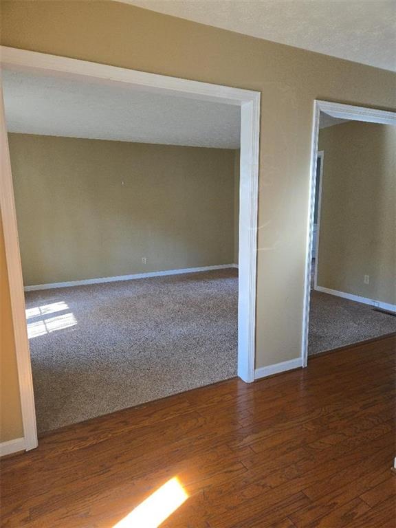 unfurnished room featuring a textured ceiling and dark wood-type flooring