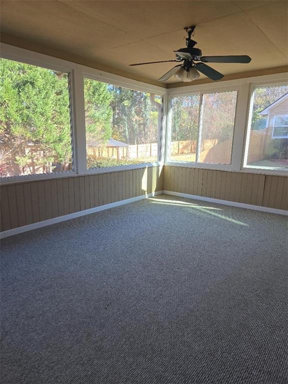 unfurnished sunroom with ceiling fan