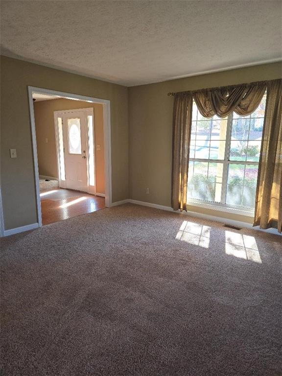 foyer entrance with carpet flooring and a textured ceiling