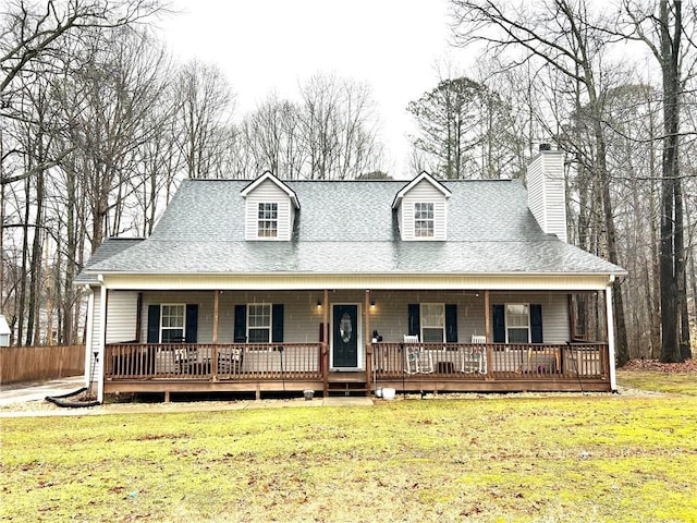 view of front of property featuring a chimney, a porch, a shingled roof, and a front lawn
