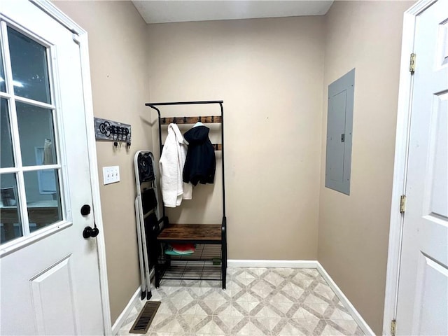 interior space with electric panel, baseboards, visible vents, and light floors