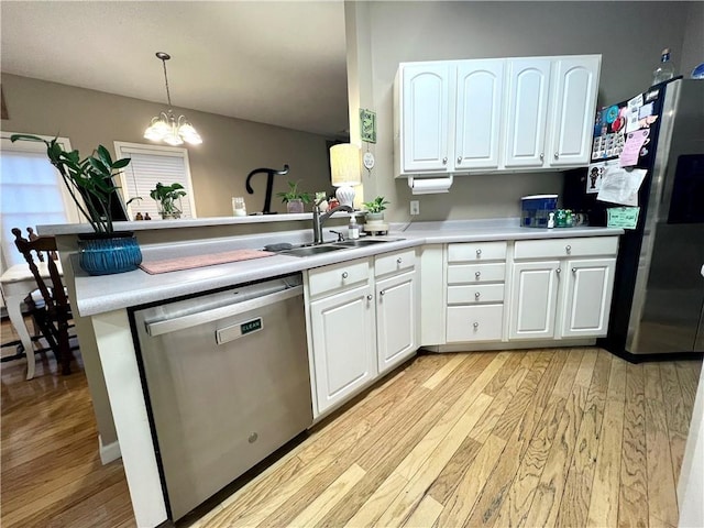 kitchen with light countertops, a sink, a peninsula, light wood-style flooring, and stainless steel appliances