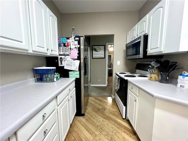 kitchen with light countertops, white cabinetry, appliances with stainless steel finishes, light wood-type flooring, and baseboards
