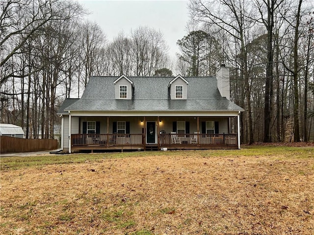 view of front facade with a chimney, a front yard, and a porch
