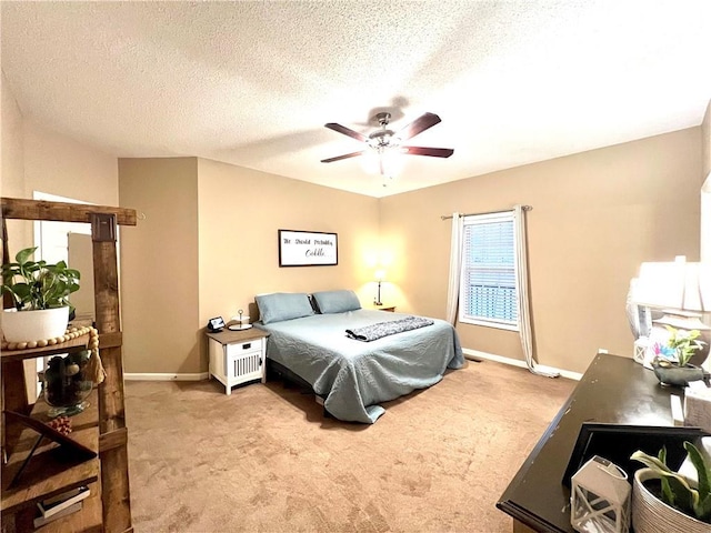 bedroom featuring baseboards, a textured ceiling, a ceiling fan, and carpet