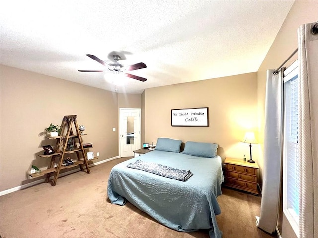 carpeted bedroom featuring baseboards, a ceiling fan, and a textured ceiling