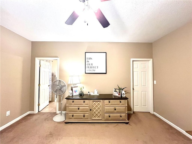 bedroom featuring baseboards, a textured ceiling, a ceiling fan, and light carpet