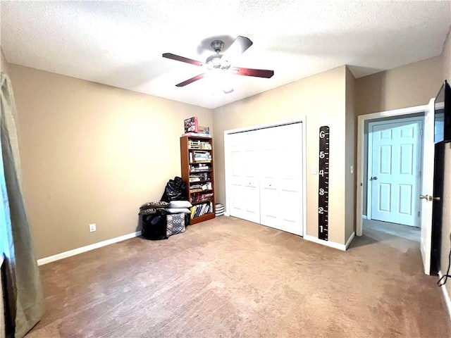 unfurnished bedroom with a closet, a textured ceiling, baseboards, a ceiling fan, and carpet floors