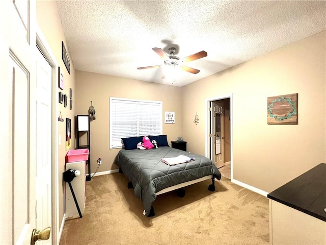 bedroom with baseboards, a textured ceiling, a ceiling fan, and light colored carpet