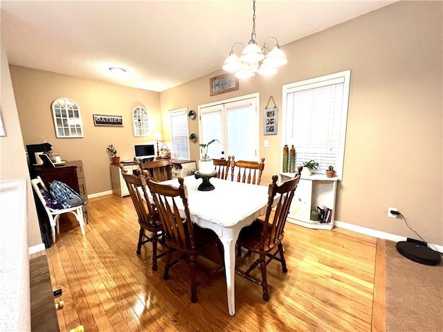 dining room with an inviting chandelier, french doors, baseboards, and light wood-type flooring