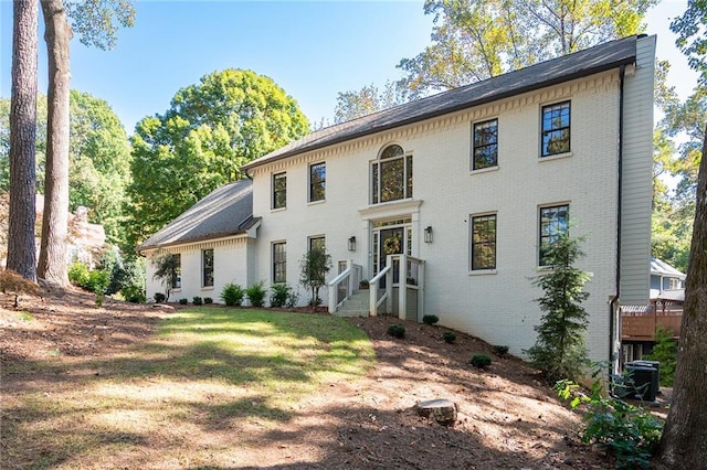 view of front of home featuring cooling unit and a front lawn