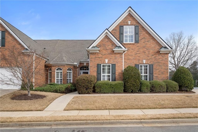 traditional home with brick siding and roof with shingles