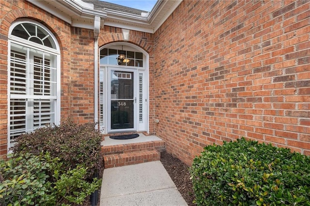 view of exterior entry with brick siding