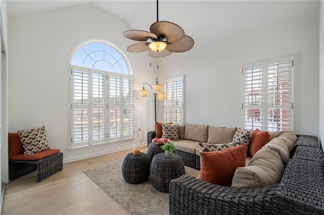 living area with vaulted ceiling, a ceiling fan, and wood finished floors