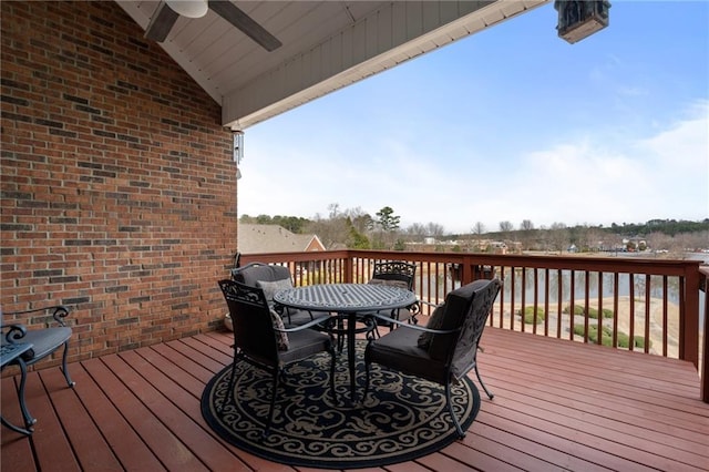 wooden deck with outdoor dining area and ceiling fan