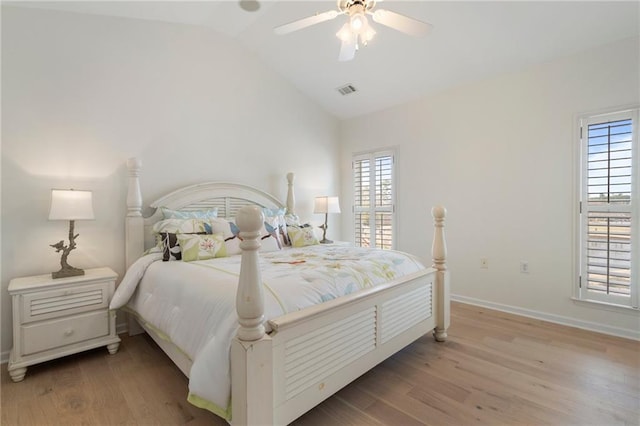 bedroom featuring light wood finished floors, visible vents, baseboards, and vaulted ceiling