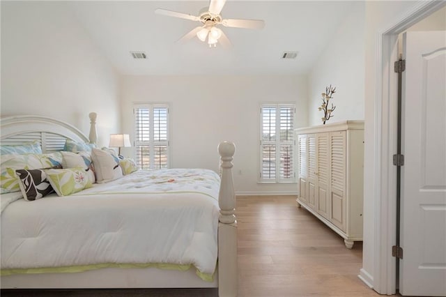 bedroom featuring lofted ceiling, multiple windows, and light wood-type flooring