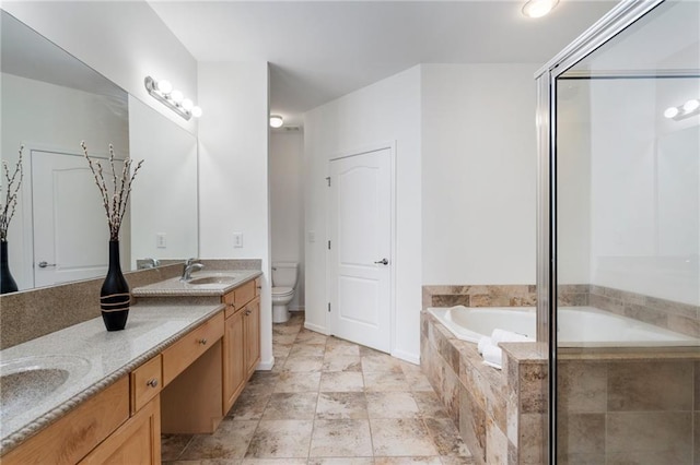 bathroom with a bath, double vanity, a sink, an enclosed shower, and toilet