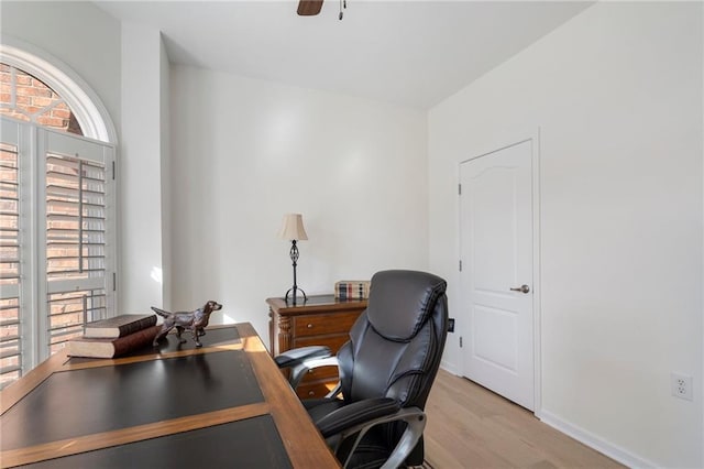 office area featuring baseboards, light wood-style floors, and ceiling fan