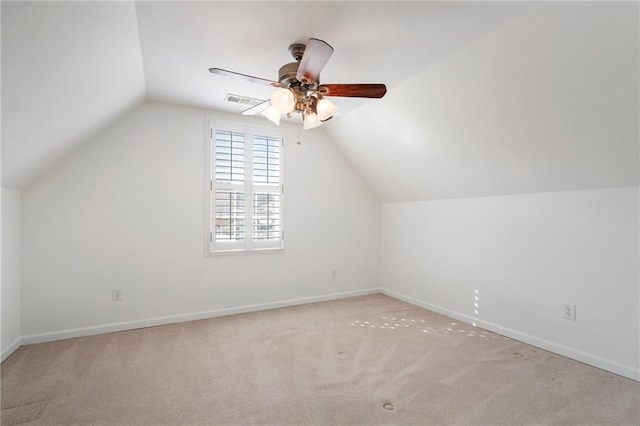 additional living space featuring visible vents, baseboards, lofted ceiling, carpet flooring, and a ceiling fan