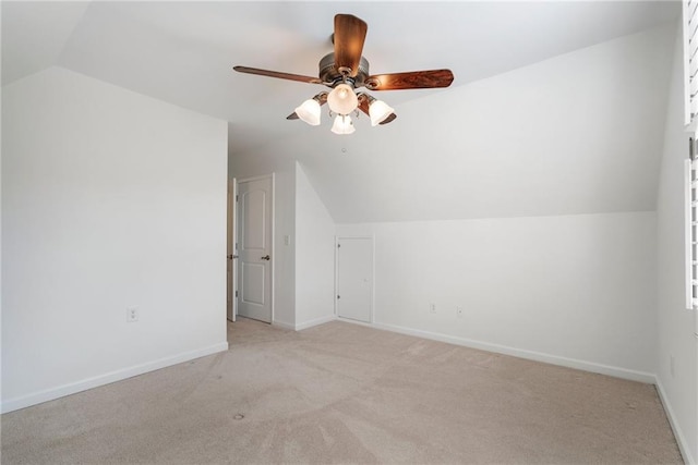 bonus room with baseboards, lofted ceiling, light colored carpet, and ceiling fan