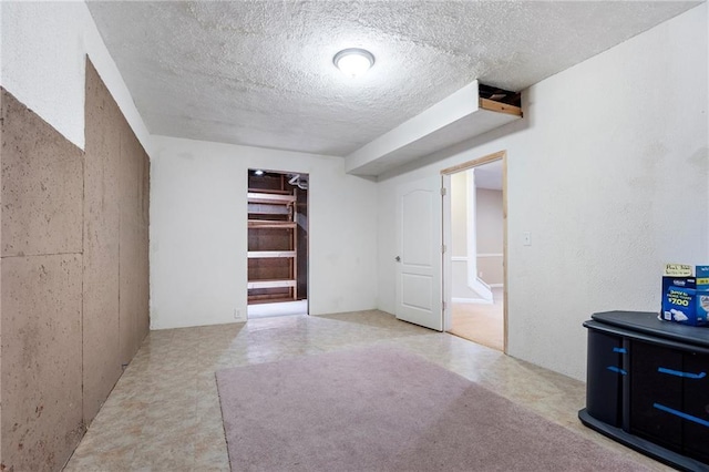 finished basement with tile patterned floors and a textured ceiling