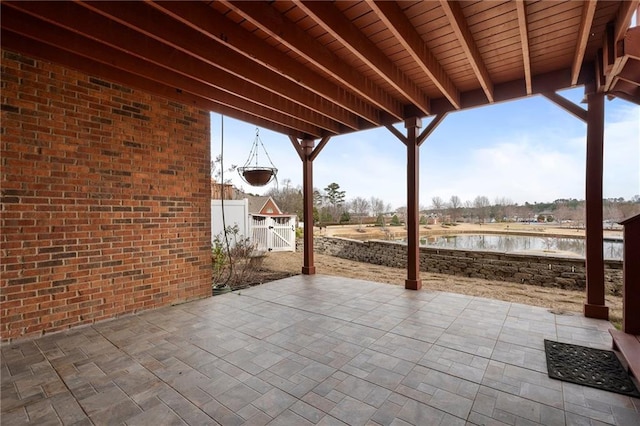 view of patio / terrace with fence, a water view, and a gate