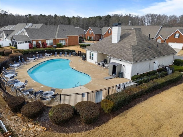 community pool with a residential view, a patio, and fence