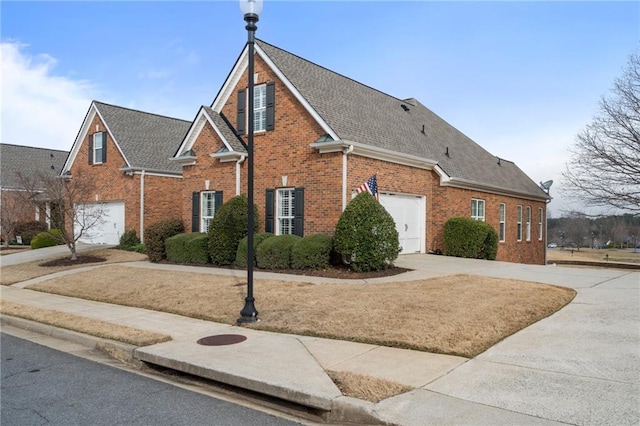 view of front of property with concrete driveway, brick siding, and a shingled roof