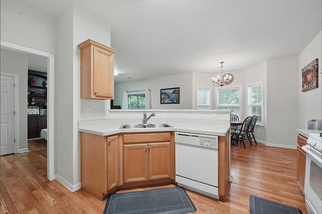2545 Gatewater Ct, Cumming, GA 30040 - kitchen with white appliances, a sink, a peninsula, light wood finished floors, and light countertops