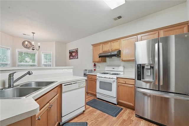 2545 Gatewater Ct, Cumming, GA 30040 - kitchen featuring white appliances, a sink, under cabinet range hood, light wood-type flooring, and a chandelier