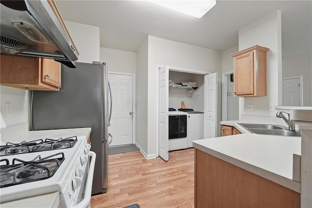 2545 Gatewater Ct, Cumming, GA 30040 - kitchen with a sink, washing machine and clothes dryer, extractor fan, white range with gas stovetop, and light wood-style floors