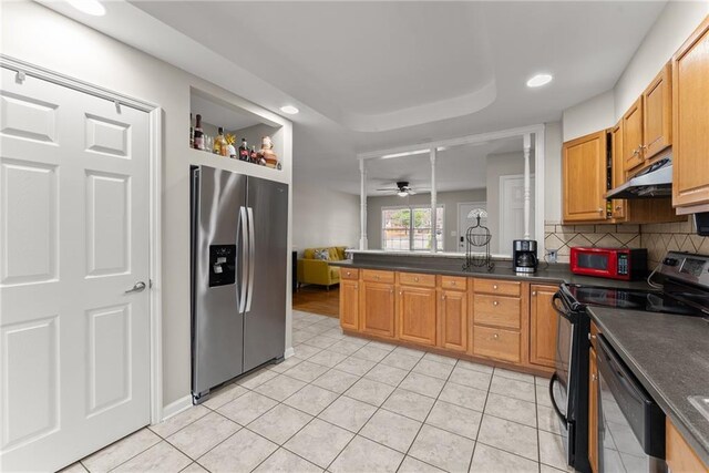 1283 Woodleigh Rd SW, Marietta, GA 30008 - kitchen featuring ceiling fan, tasteful backsplash, a raised ceiling, light tile patterned flooring, and black appliances