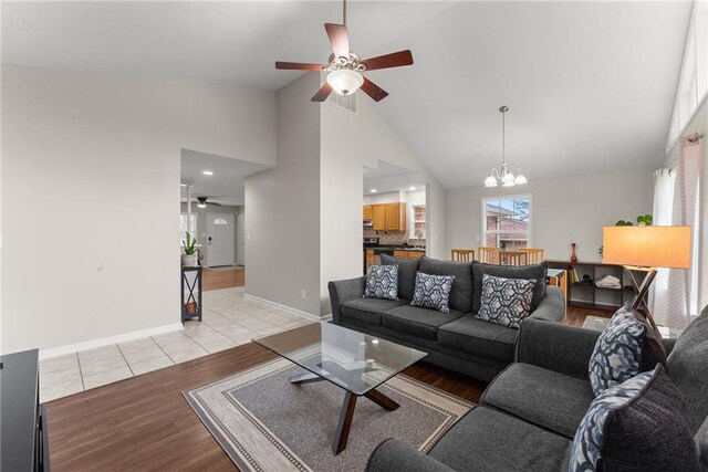 1283 Woodleigh Rd SW, Marietta, GA 30008 - living room featuring high vaulted ceiling, ceiling fan with notable chandelier, and light wood-type flooring