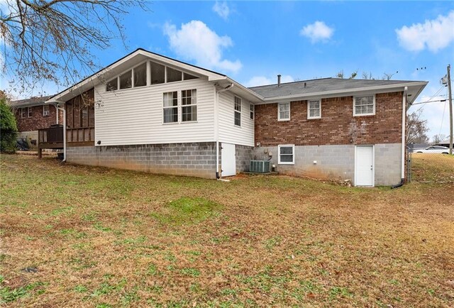 1283 Woodleigh Rd SW, Marietta, GA 30008 - back of house with a lawn, a sunroom, and central air condition unit