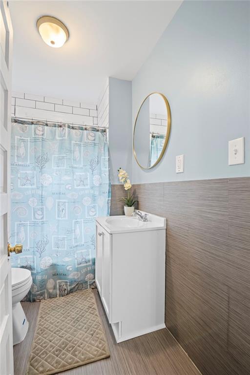 1591 Jonesboro Rd SE, Atlanta, GA 30315 - full bath featuring toilet, tile walls, vanity, and wainscoting